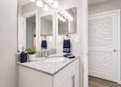 Thumbnail 16 of 40 - A bathroom with a sink, mirror, and towel rack.