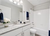 Thumbnail 17 of 40 - A white bathroom with a toilet, sink, and shower.