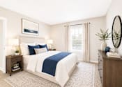 Thumbnail 15 of 40 - Sandy Springs, GA, Apartments with In-Unit Washer and Dryer - Veridian at Sandy Springs - Bedroom With A White Bed, Wood Nightstands, Large Window, Dresser, Round Mirror, And Neutral Decor.