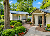 Thumbnail 34 of 40 - A small building with a black roof is surrounded by a well-manicured garden.