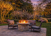 Thumbnail 39 of 40 - A fire pit in the middle of a patio surrounded by chairs.