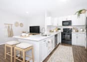 Thumbnail 10 of 25 - A kitchen with white cabinets and a black oven.