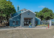 Thumbnail 6 of 25 - A blue building with a grey roof and a white circle window on the front.