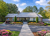 Thumbnail 33 of 40 - Our leasing office exterior filled with vibrant flowers and trees on a spring morning.