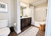 Thumbnail 14 of 30 - A bathroom with a toilet, sink, and bathtub.
