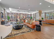 Thumbnail 11 of 24 - A modern living room with a large sofa, a coffee table, and a large window.