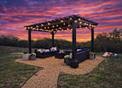 Thumbnail 19 of 24 - A gazebo with string lights is surrounded by a gravel path and potted plants.