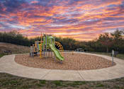 Thumbnail 17 of 24 - A playground with a green slide and a yellow and black swing set.