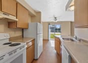 Thumbnail 2 of 7 - a kitchen with white appliances and wooden cabinets