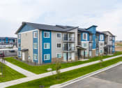 Thumbnail 7 of 19 - a row of new apartment buildings next to a street