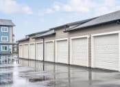 Thumbnail 9 of 19 - a row of garages with white doors in a parking lot