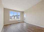 Thumbnail 18 of 19 - an empty living room with a large window and wooden floors