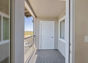 Thumbnail 16 of 19 - a covered porch with a white door and a balcony