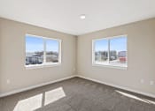 Thumbnail 11 of 19 - an empty bedroom with two windows and a carpeted floor