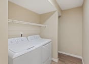 Thumbnail 19 of 19 - a white washer and dryer in a laundry room with a shelf above it