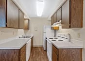 Thumbnail 1 of 5 - A kitchen with a white stove and wooden cabinets.