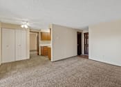 Thumbnail 3 of 5 - A room with a carpeted floor and a brown door.