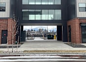 Thumbnail 18 of 18 - A modern building with a black and grey facade and a glass entrance.