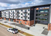 Thumbnail 5 of 18 - A white truck is parked in front of a building with a sign that says North Yards.