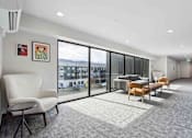 Thumbnail 6 of 18 - A room with a white chair and a grey carpet.