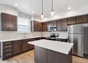 Thumbnail 9 of 18 - A modern kitchen with dark wood cabinets and stainless steel appliances.