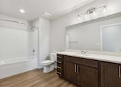 Thumbnail 10 of 18 - A white bathroom with a toilet, sink, and bathtub.