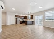 Thumbnail 14 of 18 - A spacious kitchen with wooden floors and white walls.