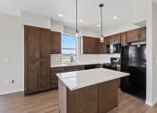 Thumbnail 2 of 13 - a large kitchen with a white counter top and black appliances