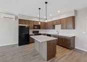 Thumbnail 8 of 13 - an empty kitchen with wooden cabinets and a white counter top