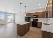 Thumbnail 9 of 13 - an empty kitchen with wooden cabinets and a white counter top