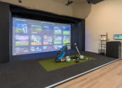 Thumbnail 3 of 19 - a room with a golf simulator and a projection screen