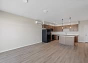 Thumbnail 10 of 13 - an empty living room and kitchen with wood flooring