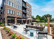 Thumbnail 45 of 48 - a patio with tables and chairs outside of a building
