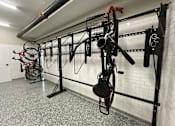 Thumbnail 27 of 48 - a workout room with bikes hanging on the wall and weights on a rack