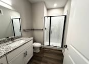 Thumbnail 5 of 34 - A bathroom with a sink, toilet, and shower.