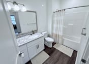 Thumbnail 54 of 61 - A white bathroom with a sink, toilet, and bathtub.
