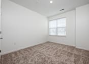 Thumbnail 56 of 61 - A room with a carpeted floor and a window with blinds.