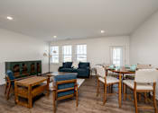 Thumbnail 48 of 61 - A living room with a fireplace and a dining table set up.
