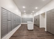 Thumbnail 34 of 34 - A long hallway with a white box in the middle and a row of mailboxes on the left.