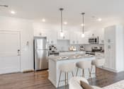 Thumbnail 20 of 34 - A modern kitchen with a center island and stainless steel appliances.