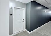 Thumbnail 22 of 34 - A white door is in a room with a grey carpet.