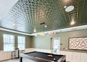 Thumbnail 2 of 34 - A pool table is in the middle of the room.