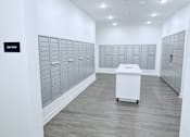 Thumbnail 10 of 34 - A mailbox room with a white mailbox on the floor.