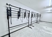 Thumbnail 9 of 34 - A set of black pull-up bars are lined up against a white wall.