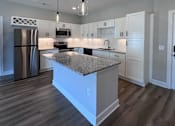 Thumbnail 33 of 34 - A modern kitchen with a granite countertop and stainless steel appliances.