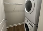 Thumbnail 34 of 34 - A white washing machine and dryer in a small laundry room.