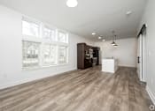 Thumbnail 13 of 48 - A room with wooden flooring and a large window.
