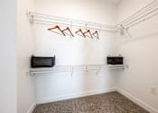 Thumbnail 9 of 48 - A white wall with a metal rack and two black bags.