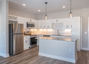 Thumbnail 27 of 34 - A modern kitchen with a granite countertop and stainless steel appliances.