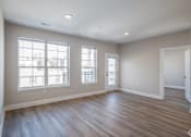 Thumbnail 26 of 34 - A room with wooden floors and two windows.